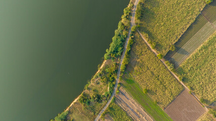 Aerial of of a riverside road on the edge of green and clean river