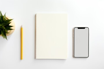 Simple workspace setup with a blank notebook, pencil, smartphone, and a small plant on a clean white surface