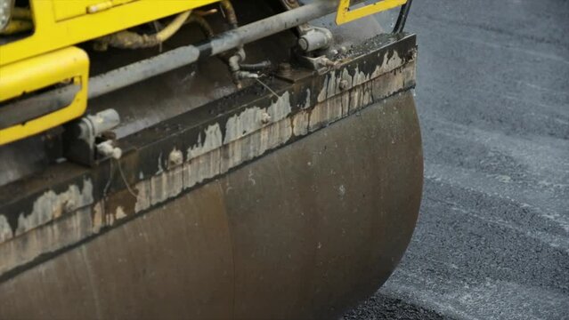 Process of asphalting road construction infrastructure by compressing, compacting, leveling and smoothing the asphalt road surface using a tandem roller