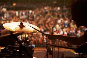 Drummer, music and crowd at stage, concert or musician in performance at festival or event with...
