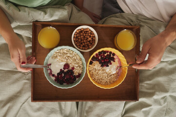Couple in love having breakfast in bed. Above view.