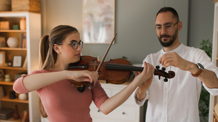 Male music teacher giving private violin lessons to a teenage girl © Stockphotodirectors