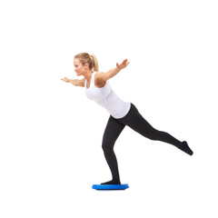 Balance, workout and fitness with woman on disk in studio for health, mindfulness or exercise. Wellness, challenge and training with person on white background for flexibility, smile or aerobics