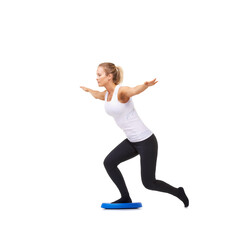 Balance, health and training with woman on disk in studio for workout, body or exercise. Wellness, challenge and fitness with female person on white background for flexibility, active or aerobics