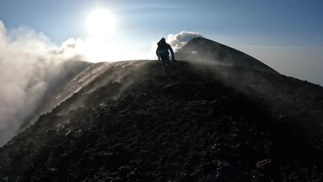 Escursionista sul cratere dell'Etna in Sicilia tra vapore e fumo