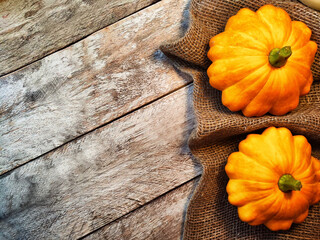 Yellow pattison on wooden boards of table and on the fabric is sackcloth or burlap. Healthy Delicious Beautiful Vegetable in autumn. Abstract Background, texture, frame, place for text and copy space