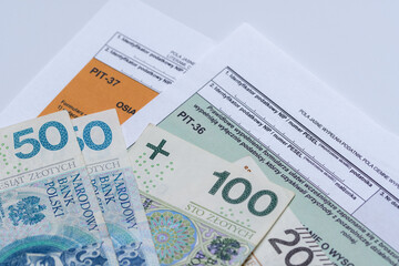 Polskie banknoty leżą na formularzach podatkowych  pi37 pit28 cit - obrazy, fototapety, plakaty