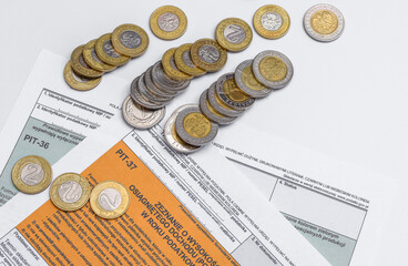Formularz podatkowy Pit 37 i stos przewróconych monet - obrazy, fototapety, plakaty