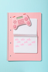 Notepads and calculator on blue background, top view