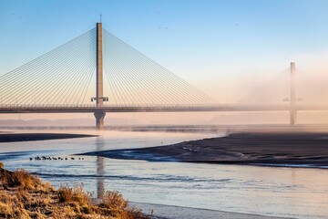 Cable-Stayed River Crossing Mersey Gateway Bridge in winter with fog