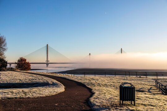 Cable-Stayed River Crossing Mersey Gateway Bridge in winter with fog from Spike Island