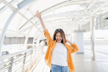 Smiling cheerful Asian girl standing and Raise your hand with enjoys freedom.