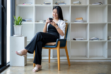 Young asian woman using smart while relaxing at resting corner.