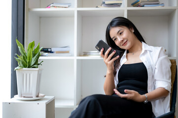 Young asian woman using smart while relaxing at resting corner.