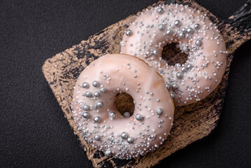 Delicious fresh donut of white or beige color with silver beads and cream