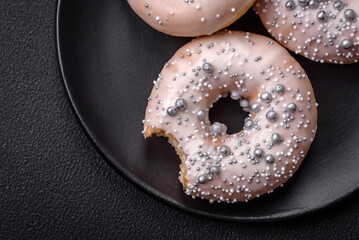 Delicious fresh donut of white or beige color with silver beads and cream