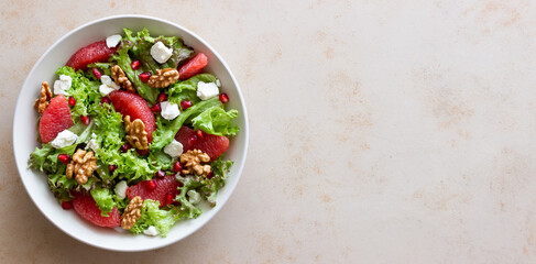 Salad with grapefruit, white cheese, pomegranate and nuts. Healthy eating. Vegetarian food. Diet.