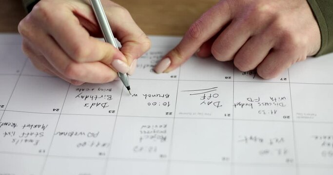Women's hands write a calendar with a pen, a close-up. Week planning, organization of tasks