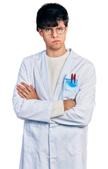 Handsome hipster young man with crossed arms wearing doctor uniform skeptic and nervous, frowning upset because of problem. negative person.