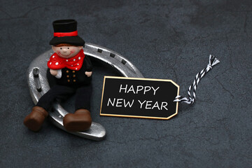 Happy New Year: chimney sweep and horseshoe with congratulations on the new year.