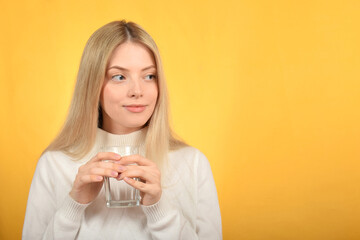 young pretty blonde woman holding a glass of water