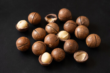Close up macadamia nuts on black background.