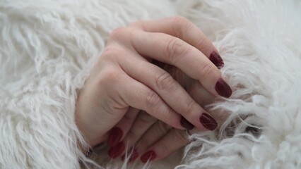 A woman in a white fur coat warms her hands from the cold, snow, frost, blizzard. Close-up of hands...