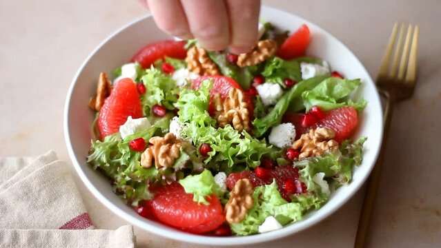 Salad with grapefruit, white cheese, pomegranate and nuts. Healthy eating. Vegetarian food. Diet.