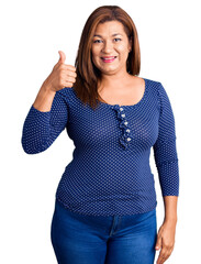 Middle age latin woman wearing casual clothes smiling happy and positive, thumb up doing excellent and approval sign