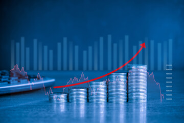 Stack of money coin on blue background with graph and red up curve arrow. Business and finance...
