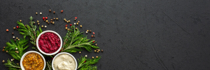 Different types of sauces in bowls with seasonings banner, rosemary and dill, thyme and and...