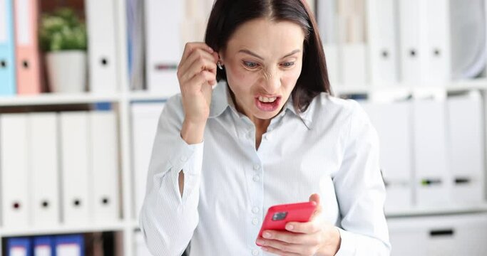 Angry woman looking at phone screen and shouting in office 4k movie slow motion. Mobile Internet problems concept