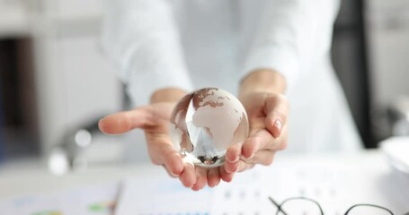 Woman holding glass globe over documents with graphs 4k movie slow motion. International relations in business concept