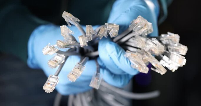Gloved engineer holds many LAN cables. Fiber optic wires concept