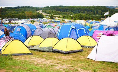 Tents, field and music festival outdoor for dancing event in forest for party celebration, rave weekend on vacation. Campsite, land and crowd for concert dj disco accommodation, park trip in nature - Powered by Adobe