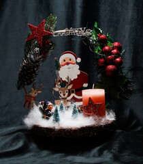 Christmas wreath in the form of a star Blue lights. Symbolic Christmas balls and ornaments. Green, white. On a black background