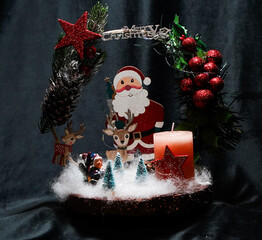 Christmas wreath in the form of a star Blue lights. Symbolic Christmas balls and ornaments. Green, white. On a black background