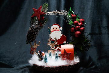 Christmas wreath in the form of a star Blue lights. Symbolic Christmas balls and ornaments. Green, white. On a black background