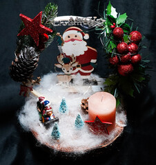 Christmas wreath in the form of a star Blue lights. Symbolic Christmas balls and ornaments. Green, white. On a black background