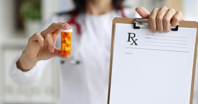 Doctor holding prescription on clipboard and jar of medicine closeup 4k movie slow motion. Discharging prescription drugs concept