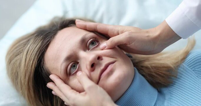 Doctor opening eyes of patient lying on couch 4k movie slow motion. Icterus sclera with cirrhosis concept
