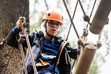 Little Boy Engaged in a High Rope Adventure Course - obrazy, fototapety, plakaty