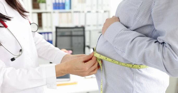 Gynecologist measures belly of pregnant woman with centimeter. Abdominal circumference by week of pregnancy concept