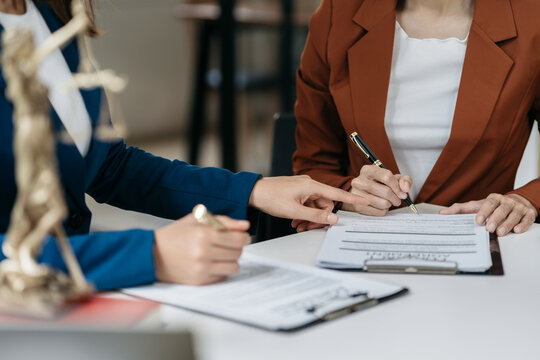 Legal counsel presents to the client a signed contract with legal law. justice and lawyer concept in office.
