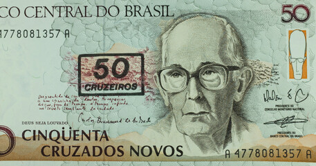 Imagen de la parte de un billete de 50 cruzeiros del Banco de Brasil. Retrato de Carlos Drummond de Andrade (1902-1987), con las casas y montañas de Itabira - obrazy, fototapety, plakaty