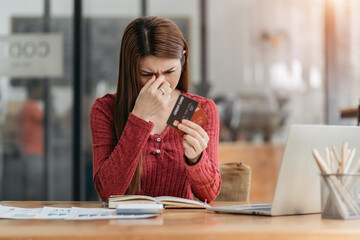 young asian woman cover her face after stressed with credit card debt.