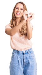 Fototapeta premium Young beautiful caucasian woman with blond hair wearing casual clothes smiling in love doing heart symbol shape with hands. romantic concept.