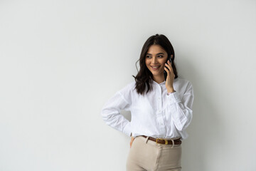 Portrait of a young business woman talking on mobile phone isolated over white background