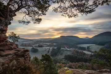 Hilly landscape shot on a sandstone rock in the forest. Cold morning mood at sunrise at a...
