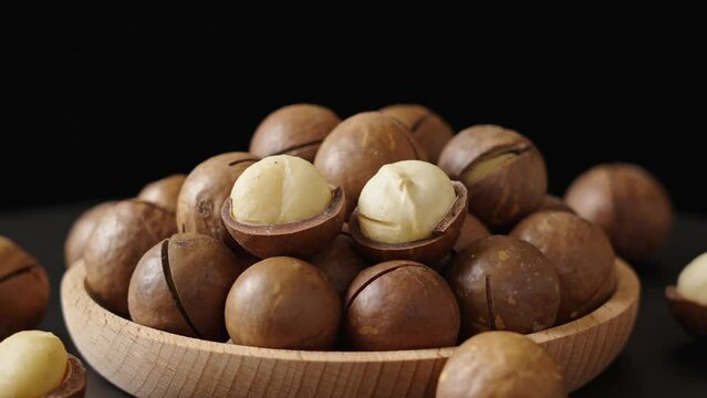 Close up macadamia nuts in plate on black background
